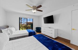 a bedroom with two beds and a flat screen tv at Ground Floor Beachfron 2Steps From Amenities Saida in South Padre Island +41 photos