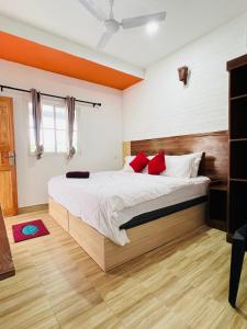 a bedroom with a large bed with red pillows at Finimas Residence in Thimarafushi
