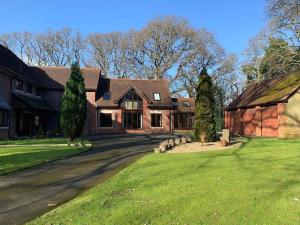 a large brick house with a yard and a barn at Little Luckford in Wareham