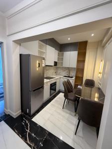 a kitchen with a black refrigerator and a table at Айни60 in Dushanbe