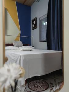 Cama blanca en habitación con espejo en Transient Siete Barcelone B&B -Studio Type Valleyhomes Patul, en Plaridel