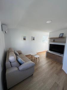 a living room with a couch and a television at PortoHome Ático in Portomarin