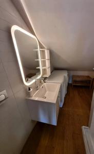 een badkamer met een wastafel en een spiegel en 2 bedden bij Bellavita Rooms-Matera Arco 34 in Matera