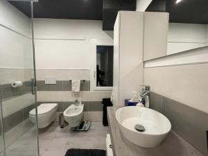 a white bathroom with a sink and a toilet at La Violetta Montemerlo in Villa Marin