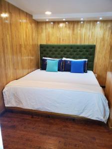 a bedroom with a large bed with a green headboard at Rooftop Rooms in Male City