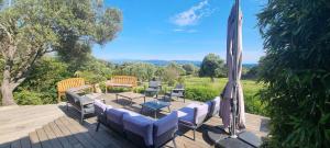 Un patio con una mesa y sillas y una sombrilla. en Maison accès direct plage corse du sud, en Coti-Chiavari