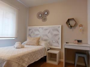 a bedroom with a bed and a clock on the wall at Pensión Cabezas in Lugones