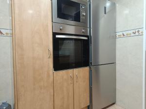 a kitchen with a microwave and a refrigerator at Habitación privada con baño privado tranquilidad y comodidad in Vilanova del Camí