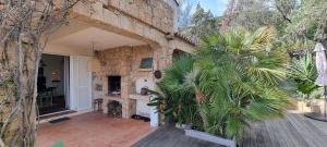 una casa con un patio con un muro de piedra en Maison accès direct plage corse du sud, en Coti-Chiavari