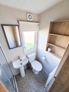 a small bathroom with a toilet and a sink at 3 Bed Holiday Home - Birchington Vale in Margate