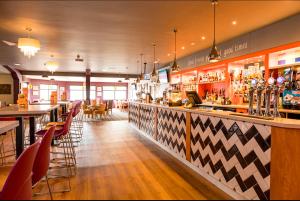 a bar in a restaurant with chairs and a counter at 3 Bed Holiday Home - Birchington Vale in Margate