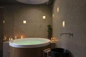 a bathroom with a tub with candles in it at La Maison Coloniale Suite e Zona Wellness free in Cagliari