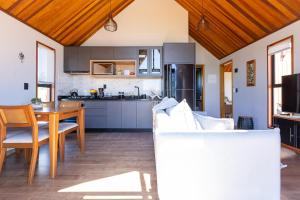a kitchen and living room with a table and a couch at Cabanas Purunã Ipê-Amarelo in Balsa Nova