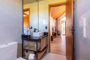 a bathroom with a sink and a mirror and a toilet at Cabanas Purunã Ipê-Amarelo in Balsa Nova +64 photos