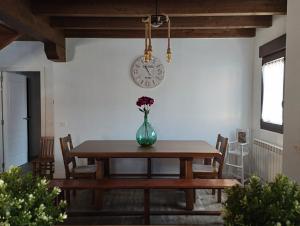 a dining room table with a vase of flowers on it at ALMA de la RIBERA in Peñafiel