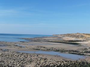 a beach with rocks and the ocean on a clear day at Les loupiots in Hardinghen