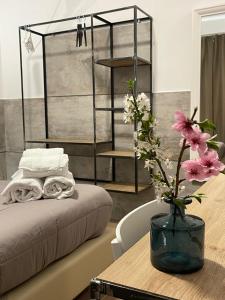 een kamer met een tafel met een bed en een vaas met bloemen bij San Silverio B&B in Rome