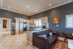 Una sala de estar con un sofá y una cocina. en Millwood Apartment, en Ciudad del Cabo 12 fotos más