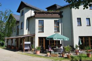 Ein Gebäude mit Leuten, die draußen sitzen. in der Unterkunft Hotel Obere Mühle in Bad Elster