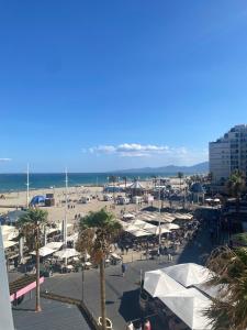 a view of a beach with white umbrellas and the ocean at Le calme à proximité de la mer in Canet-en-Roussillon