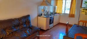 a living room with a couch and a kitchen at El Lapacho in Paraná