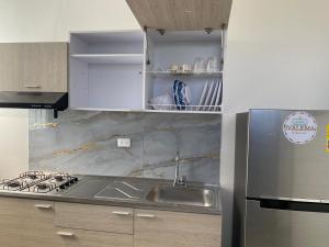 a kitchen with a sink and a stainless steel refrigerator at IVALEMA - Apartamento turístico in Valledupar