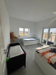 a bedroom with two beds and a teddy bear at Neubau Penthouse - mit schöner Aussicht - 15min von Köln in Pulheim