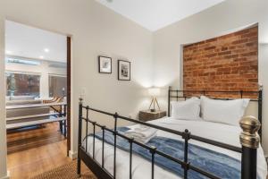 a bedroom with a bed and a brick wall at Lovely 1-BR Suite in the Heart of Adams Morgan in Washington, D.C.