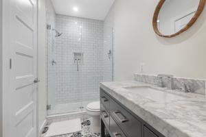 a white bathroom with a sink and a toilet at Lovely 1-BR Suite in the Heart of Adams Morgan in Washington, D.C.