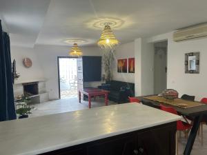 eine Küche und ein Wohnzimmer mit Tisch und Stühlen in der Unterkunft Las Cumbres 1 in El Puerto de Santa María