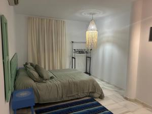 ein Schlafzimmer mit einem Bett und einem Kronleuchter in der Unterkunft Las Cumbres 1 in El Puerto de Santa María + 21 Fotos