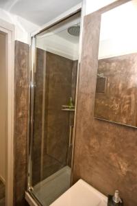 une douche avec une porte vitrée dans une salle de bain dans l'établissement Smart House, à Gênes