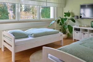 a bedroom with a bed and a tv and two windows at Heideaway in Sprockhövel