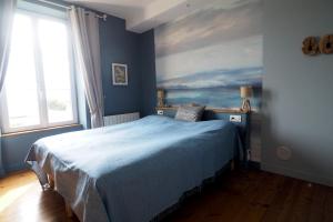 una camera da letto con un letto e un dipinto sul muro di La Maison de 1868 a Vendeuvre