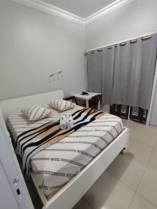 a bedroom with a bed with a striped blanket at Hotel Amanhecer -650M DA FERINHA DA MADRUGADA ,1,3 KM DA 25 DE MARÇO, 550M DO MERCADÃO MUNICIPAL ,1,1 KM DA ESTAÇÃO DA LUZ in São Paulo