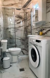 a bathroom with a washing machine and a toilet at Pangrati spot in Athens
