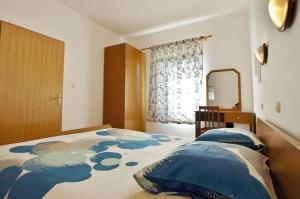 a bedroom with a large bed and a mirror at Dada Apartments in Lopar