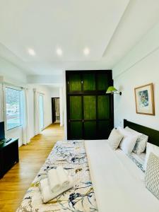 a bedroom with a large white bed with a large window at VALE MAR Guest in Ribeira Brava