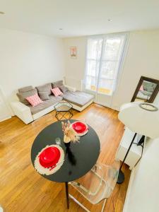 a living room with a table and a couch at Charming T2 Cozy close to Orly airport in Athis-Mons