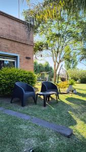 zwei Stühle und eine Bank in einem Hof mit Spielplatz in der Unterkunft Bungalow los angeles in Villa Elisa