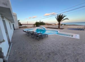 un patio con sedie e una piscina di Finca PiedraNegra a Tías