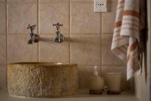 a bathroom sink with two faucets on top of it at B&B Candelária in Loulé +48 photos