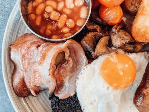 a plate of breakfast food with eggs and beans at Avocet Cottage in Lucker