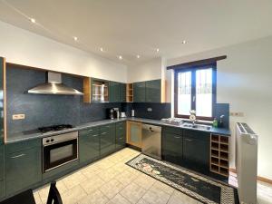 a kitchen with green cabinets and a sink and a window at Aux portes du marché in Verviers