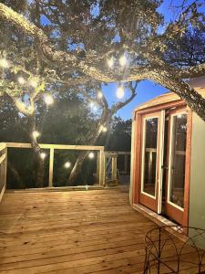 a deck with a tree with lights on it at Pennington Grove in Gatesville +8 photos