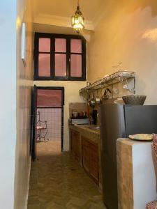 a kitchen with a refrigerator and a table and a window at dar hassbia in Fez +38 photos