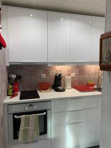 a kitchen with white cabinets and an oven at La Bussière in La Bussière