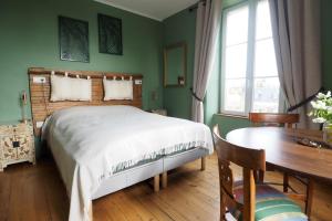 una camera da letto con un letto, una scrivania e un tavolo di La Maison de 1868 a Vendeuvre