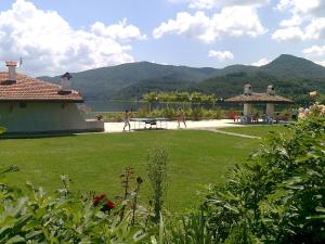 Un groupe de personnes se promenant autour d'une cour avec un lac dans l'établissement Family Hotel Belvedere, à Dŭlgopol