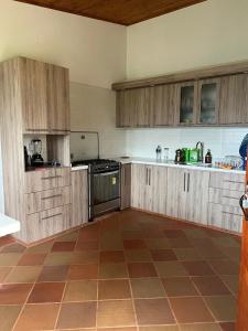 a kitchen with wooden cabinets and a tiled floor at Casa campestre Villa Transito in San Agustín +27 photos